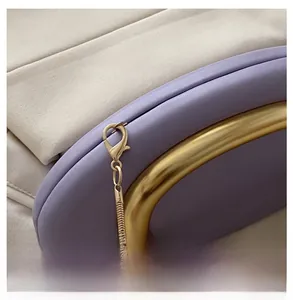 Detail of lavender leather evening bag with golden metal ring handle and chain strap