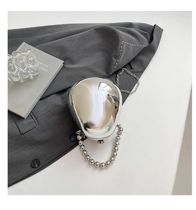 Dettaglio di una pochette rigida argento a specchio a forma di uovo con manico a catena