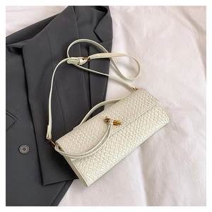 Détail du sac tressé blanc avec boucle nœud dorée et bandoulière réglable chic