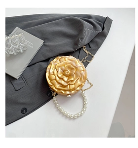 Macro shot of amber acrylic rose evening bag with pearl handle and golden chain link
