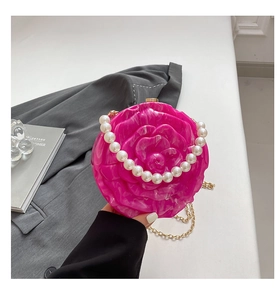 Detail of rose pink acrylic handbag with 3D floral relief and pearl handle