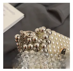 Detailed shot of pearl bead chain with silver clasp and black camellia flower charm