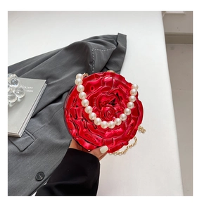 Detail of red rose acrylic clutch bag with 3D petals, pearl handle and gold chain