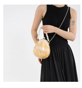 Dettaglio della pochette da sera marmorizzata a forma di uovo con manico di perle