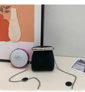 Close-up of black litchi pattern leather mini bag with silver chain and metal clasp