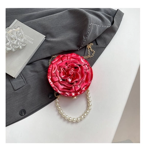 Close-up of red 3D rose acrylic evening bag with pearl handle and golden chain strap