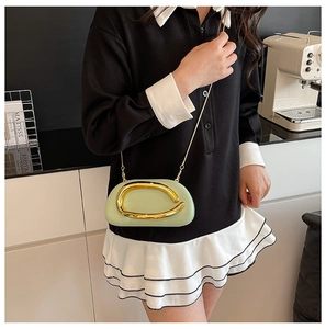 Detail of mint green oval bag featuring bold gold ring hardware and sleek chain strap