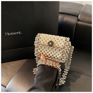 Detail of hand-woven pearl crossbody bag with a white camellia flower charm detail