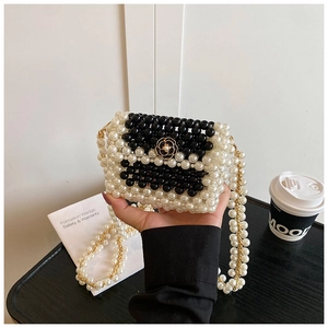 Detailed close-up of a woven pearl mini bag featuring a black camellia flower clasp