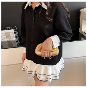 Close-up of black and white long sleeve dress with polo collar and layered ruffle hem