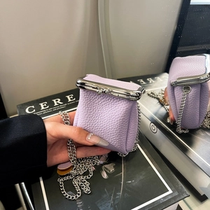 Lavender mini kiss-lock bag with lychee texture and silver chain strap on a mirror