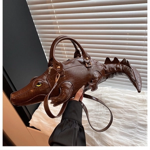 Detailed view of the 3D crocodile shape and embossed texture on a brown handbag