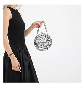 Detail of silver rose-shaped acrylic evening bag with beaded handle and high-gloss finish