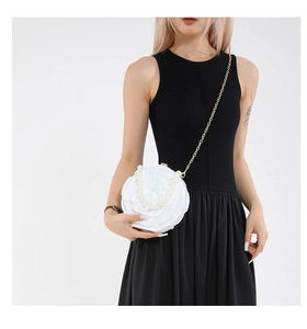 Detail showing the white 3D floral evening bag with pearl handle and golden chain strap