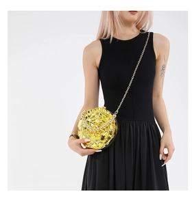 Detailed macro of gold rose flower evening clutch with metal petals and pearl handle