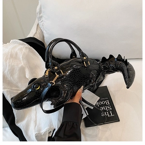 Close-up of creative crocodile shaped handbag showing textured faux leather and gold zipper