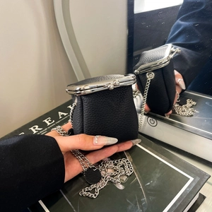 Close-up of mini black litchi grain coin purse with silver kiss-lock and metal chain