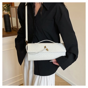 Détail du sac à bandoulière tressé blanc avec fermoir rotatif en métal doré