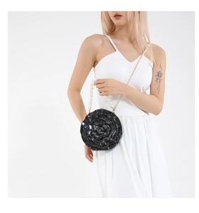 Detail of black acrylic 3D rose clutch bag with pearl handle and gold chain strap