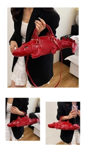 Detail of red crocodile-shaped handbag featuring embossed texture and metal hardware