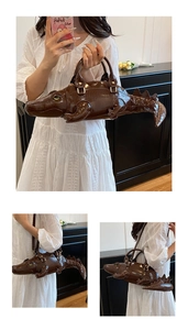 Detail view of the brown crocodile-shaped handbag with textured scales and adjustable strap