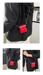 Macro detail of red lychee leather mini crossbody bag with silver chain and metal clasp