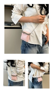 Detail of pink lychee leather mini bag with silver metal kiss lock and chain strap