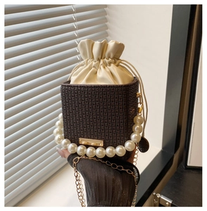 Detail der Vintage-Eimertasche mit Perlengriff und Metallkettenriemen