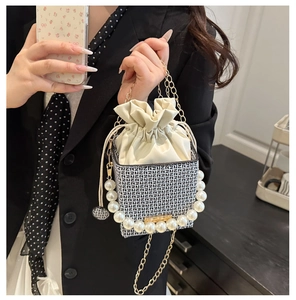 Close-up of pearl handle and chain strap on monogram drawstring bucket bag
