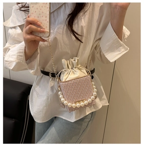 Detail of checkered bucket bag with pearl handle and golden chain strap for women