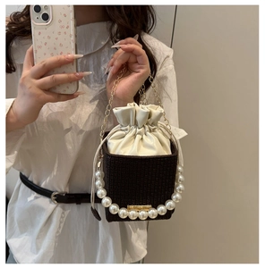 Detail der Retro-Beuteltasche mit Perlengriff, gewebtem Boden und Goldkette