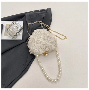 Detailed view of heart-shaped lace evening bag with 3D roses and pearl handle