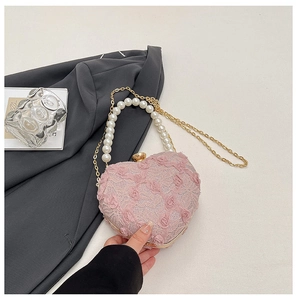 Close-up of pink lace heart bag with pearl handle and 3D floral accents for parties