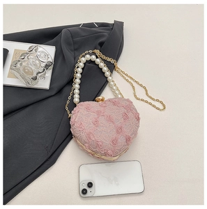 Size comparison of heart-shaped pink lace evening bag with pearls and chain