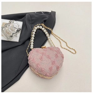 Close-up of pink heart lace handbag with 3D roses, pearl handle and gold chain strap