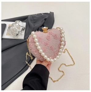 Detail of pink heart-shaped lace bag with pearl handle and jewel clasp closure