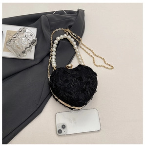 Close-up of heart-shaped evening bag with lace flower texture and pearl handle