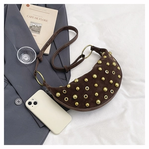 Detailed close-up of dark brown suede crescent bag with punk style gold studs