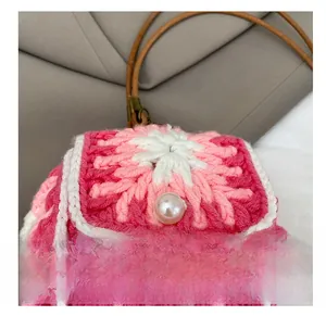 Detailed macro of the handmade floral crochet pattern and white pearl button closure