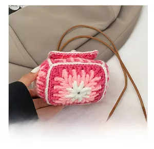 Detail shot of the durable hand-knitted floral bottom and pink woven texture of the mini bag