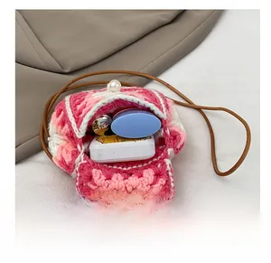 Detail view of the mini knit crossbody bag interior showing storage for cosmetics