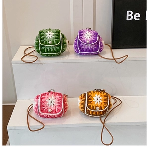 Detail of four colorful handmade crochet mini bags with floral patterns and pearl decor