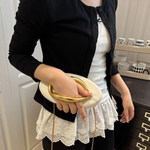 White oval evening clutch with gold ring handle and metal chain strap for women
