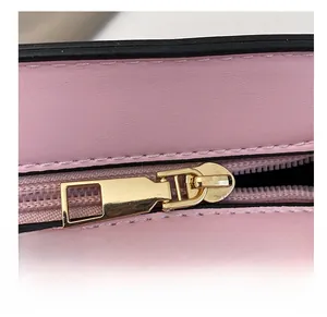 Close-up of premium gold-tone metal zipper on light pink lychee pattern leather bag