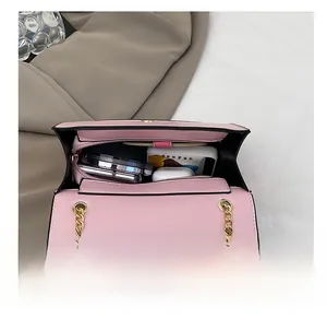 Spacious interior of the pink chain crossbody bag holding a phone and cosmetics