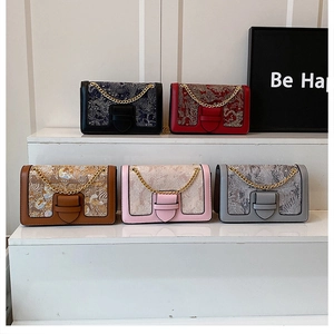 Detailed row of vintage embroidered chain bags in black, red, brown, pink, and grey