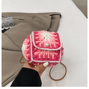 Detail of pink floral crochet knit bag with a pearl buckle and brown shoulder strap