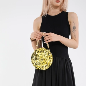 Elegant gold rose acrylic evening bag with beaded handle shown by a fashion model