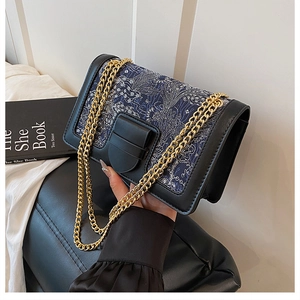 Detail of vintage navy jacquard crossbody bag with gold chain and wave pattern texture