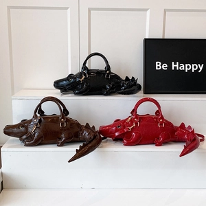 Crocodile shaped patent leather handbags in black, brown and red with embossed texture